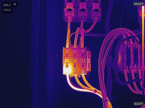 106 Close-up of illuminated electrical circuit board with connected wires in low light.
